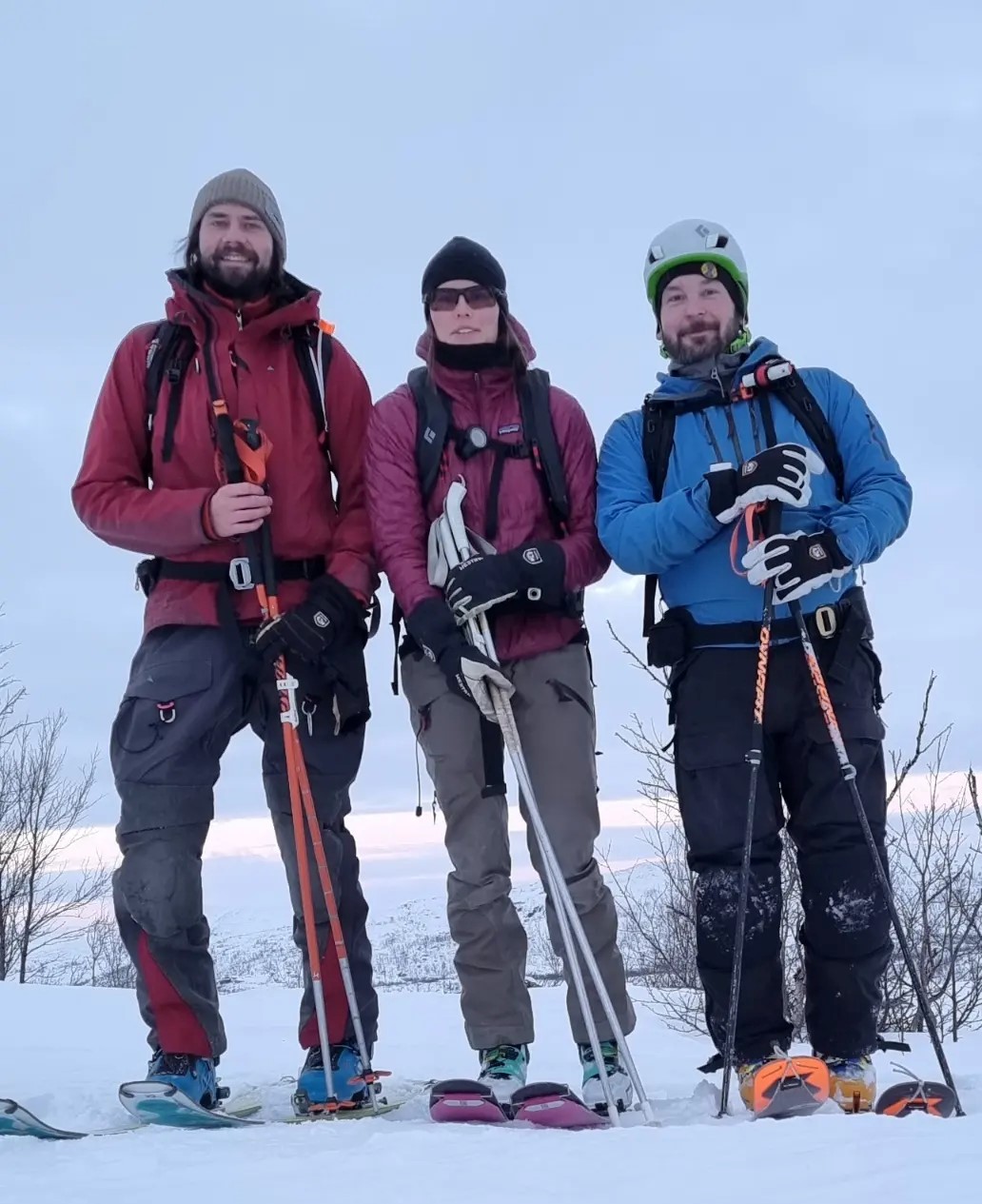 Stefan Hedlund, Moa Almquist och Erik Boström poserar framför kameran i skidutrusnitn och snöklädda fjäll i bakgrunden.